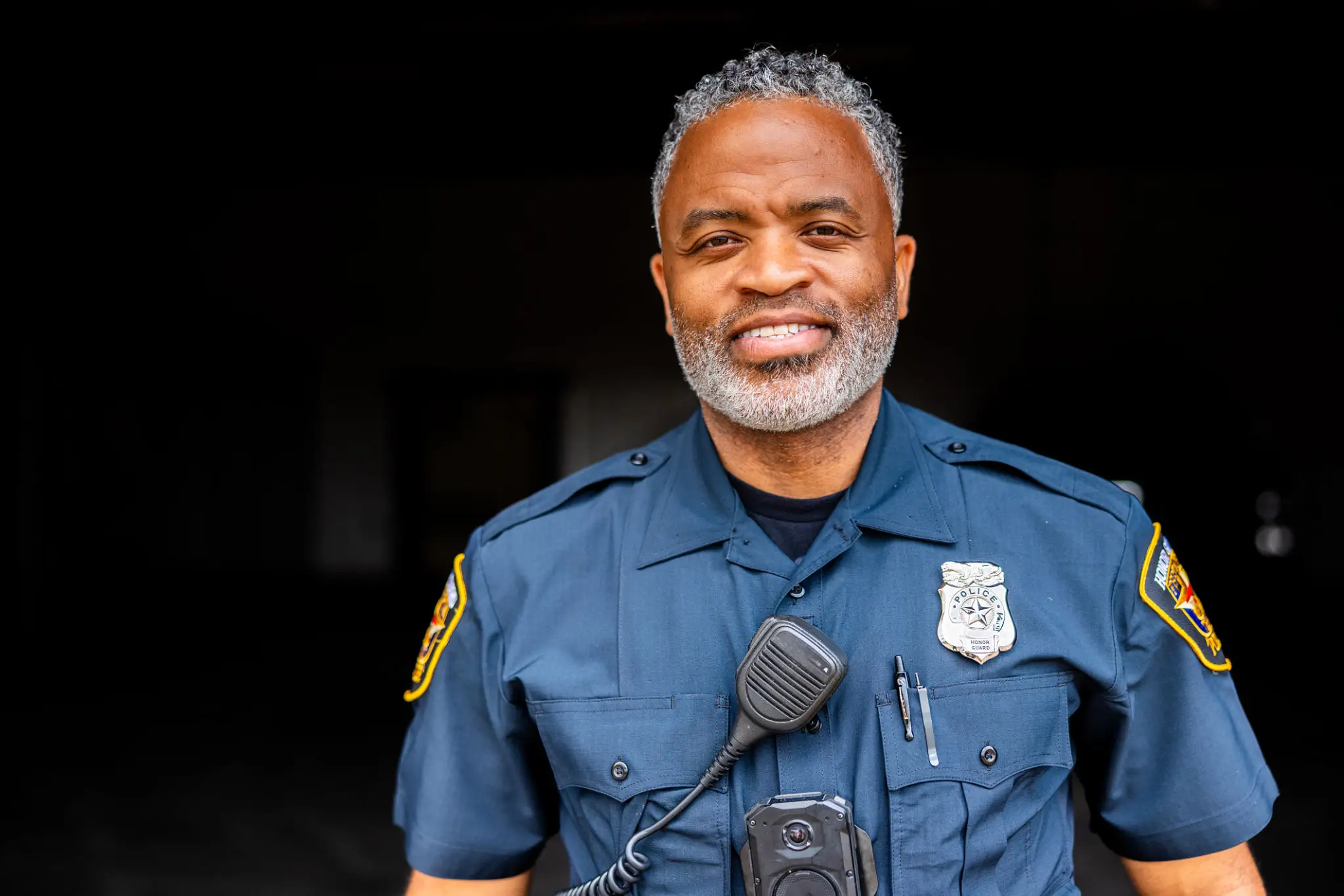 Smiling police officer in blue uniform.