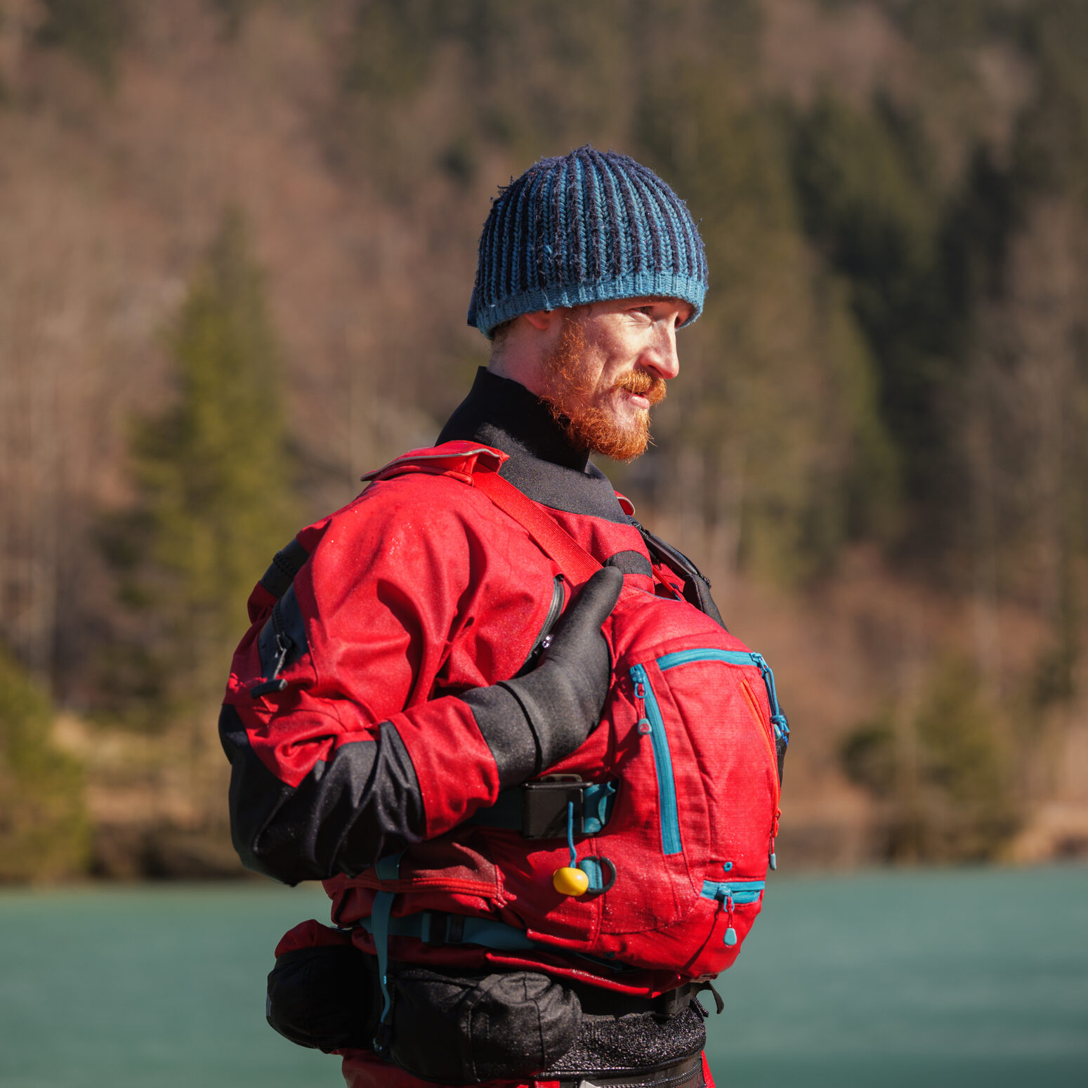 Man in red gear by a lake